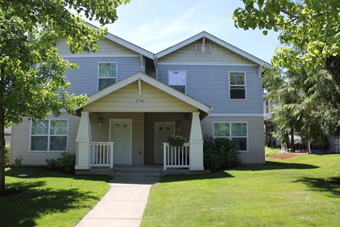 A two-story house with a front porch and a white door.